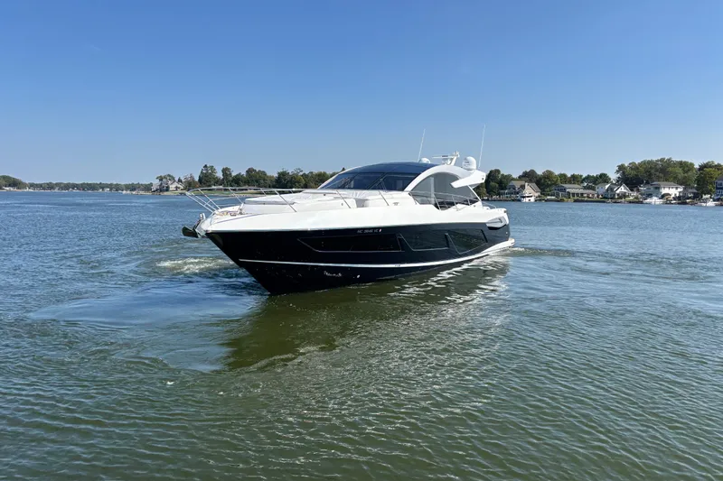  Yacht Photos Pics 2018 Sunseeker Predator 74 yacht cruising on a calm lake under clear blue skies.