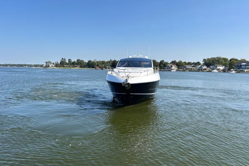  Yacht Photos Pics 2018 Sunseeker Predator 74 yacht cruising on a calm lake with houses in the background.