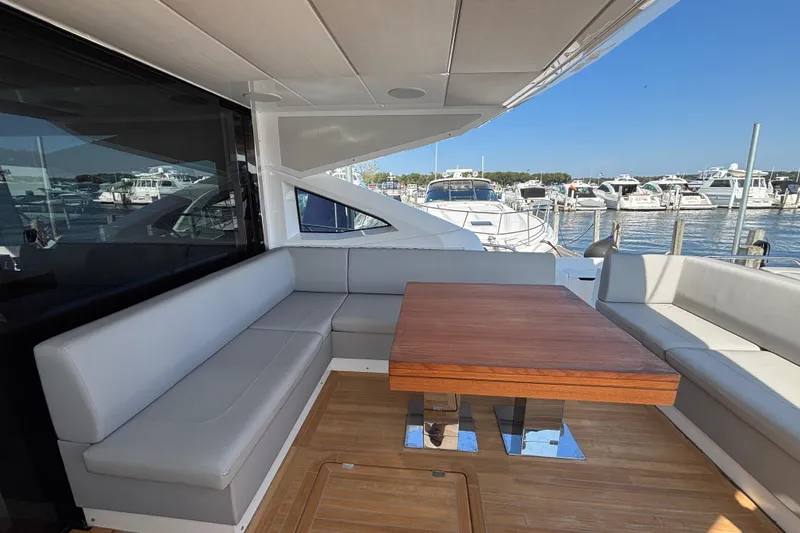  Yacht Photos Pics Luxurious Sunseeker Predator 74 yacht interior with elegant seating and wooden table, docked at marina.