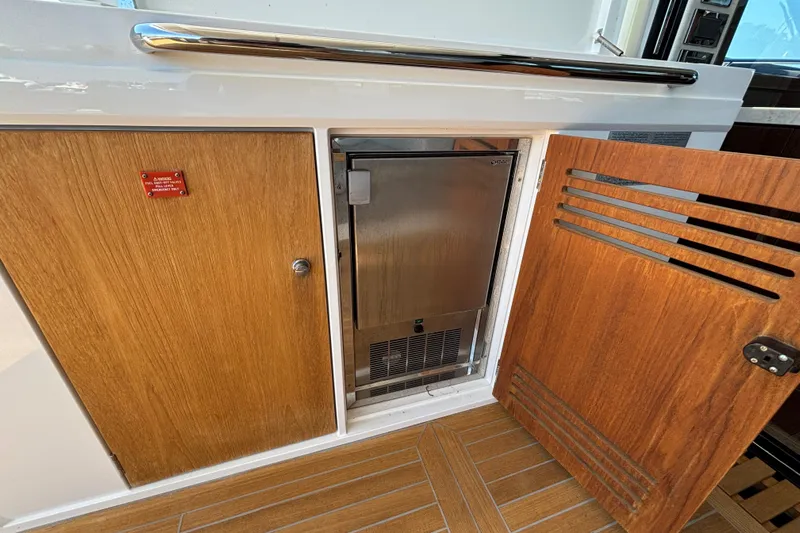  Yacht Photos Pics Sunseeker Predator 74 yacht interior, featuring wooden cabinetry and a built-in stainless steel appliance.