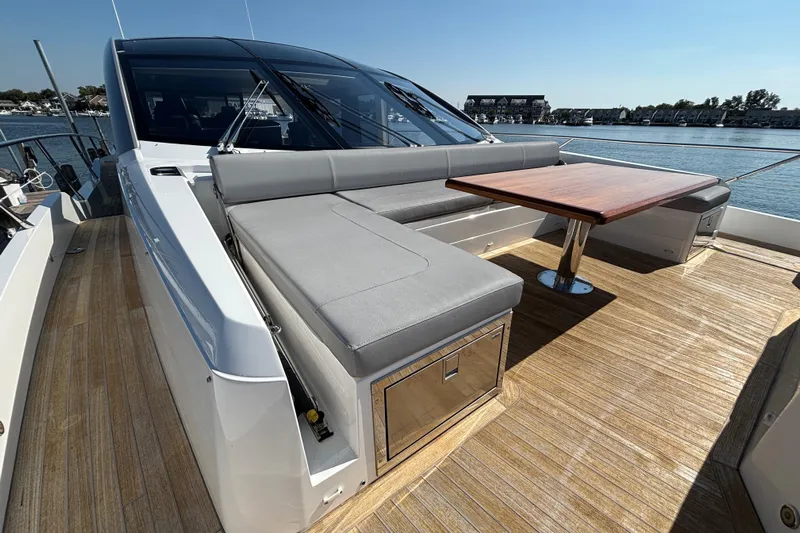  Yacht Photos Pics 2018 Sunseeker Predator 74 yacht with sleek deck seating and wooden table.