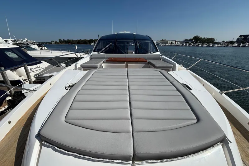 Yacht Photos Pics 2018 Sunseeker Predator 74 yacht with spacious sunbed, docked in a marina.