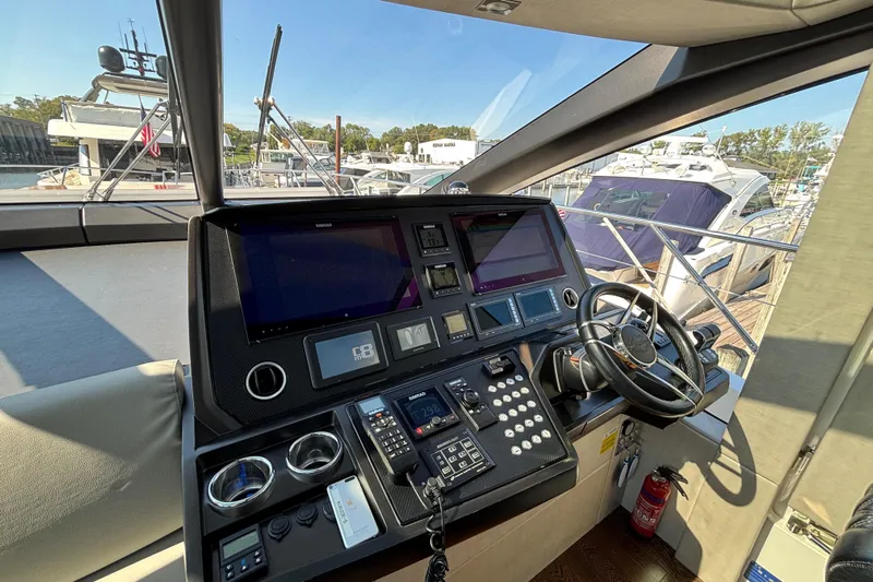  Yacht Photos Pics Helm of 2018 Sunseeker Predator 74 yacht with modern navigation equipment and steering wheel.