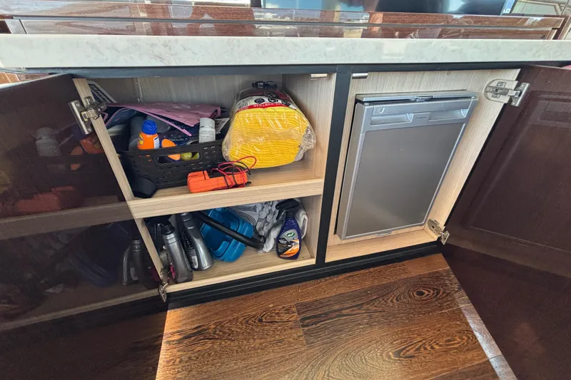  Yacht Photos Pics Open cabinet on Sunseeker Predator 74 yacht, showcasing storage and supplies.