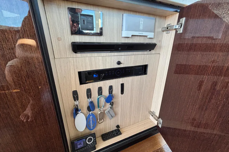  Yacht Photos Pics Interior cabinet of 2018 Sunseeker Predator 74 yacht with electronic controls and key storage.