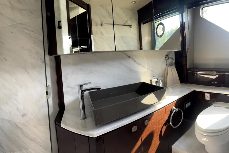  Yacht Photos Pics Luxurious bathroom in 2018 Sunseeker Predator 74 yacht with modern fixtures and marble accents.