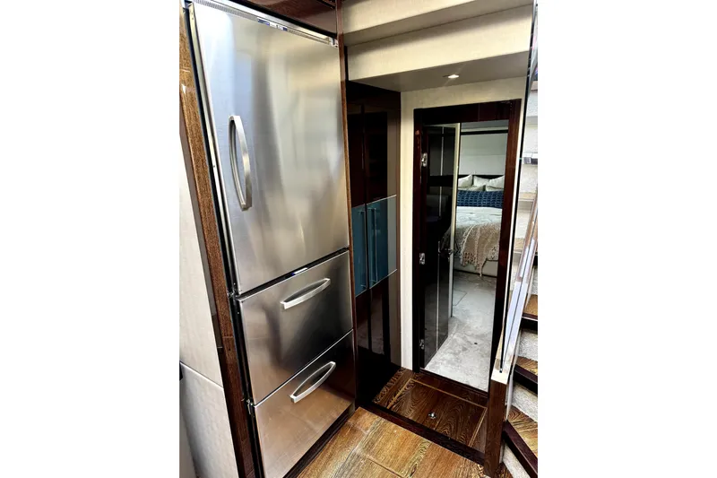  Yacht Photos Pics Luxurious interior of 2018 Sunseeker Predator 74 yacht, featuring stainless steel appliances and elegant bedroom.