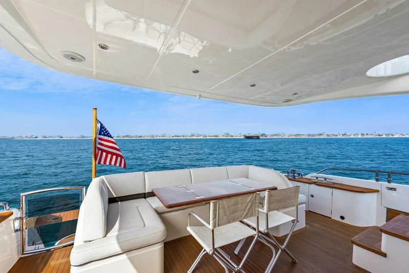 La-z-buoy Yacht Photos Pics Luxurious 2015 Princess 72 Motor Yacht deck with seating, ocean view, and American flag.