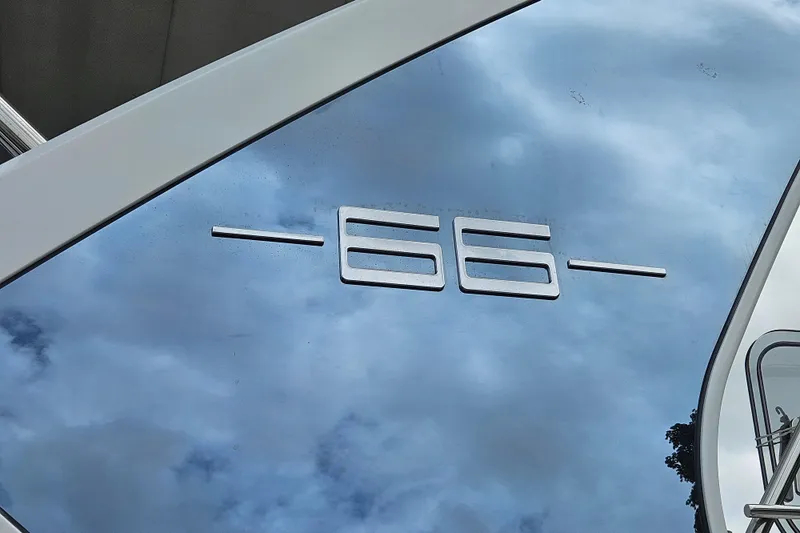  Yacht Photos Pics Reflective surface with "66" emblem on 2022 Azimut yacht, under cloudy sky.