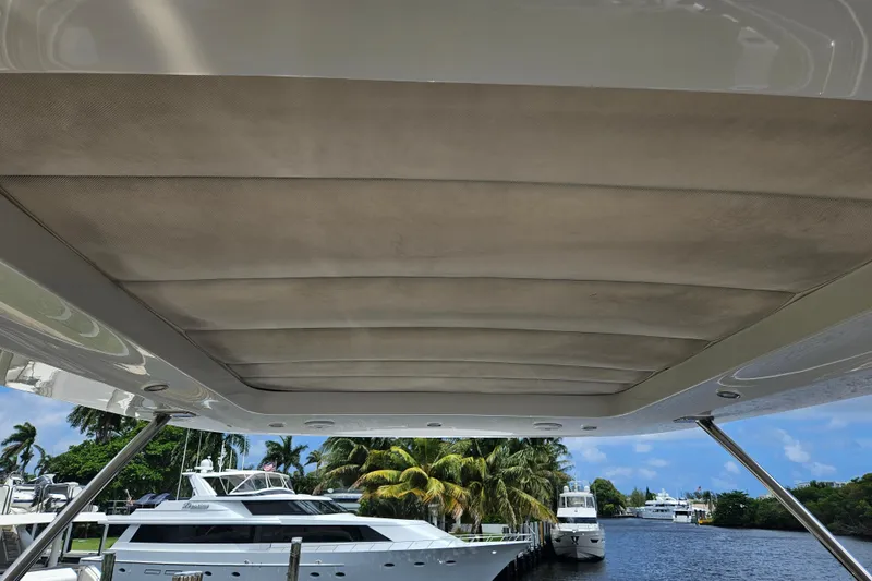  Yacht Photos Pics 2022 Azimut 66 yacht with covered deck, docked near palm trees and waterway.