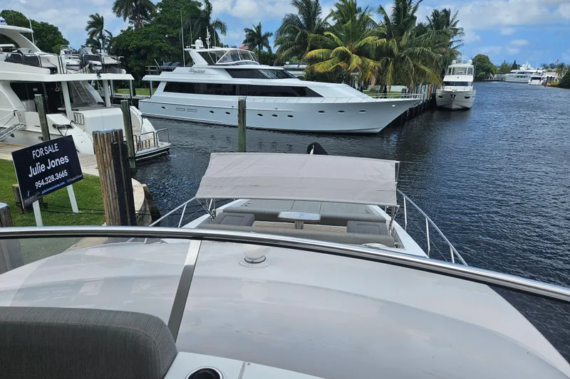  Yacht Photos Pics Luxury yachts docked in marina, featuring 2022 Azimut 66, surrounded by palm trees and water.