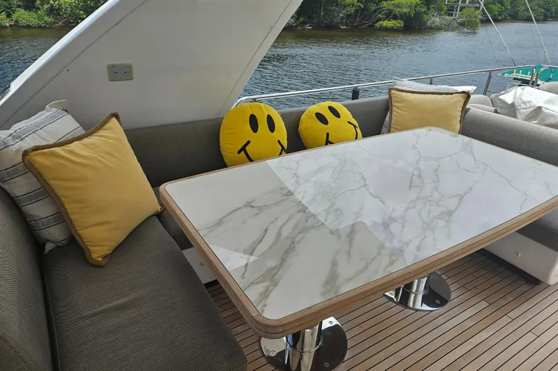  Yacht Photos Pics Outdoor seating area on 2022 Azimut 66 yacht with marble table and smiley cushions.