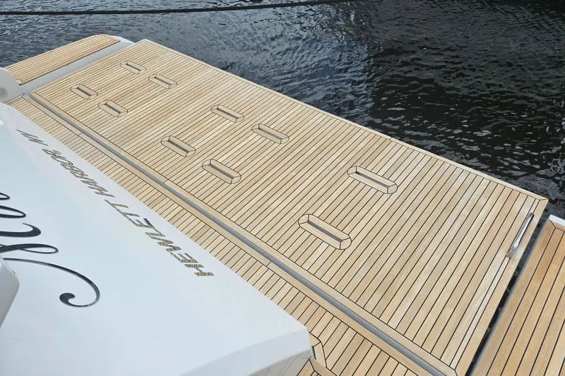  Yacht Photos Pics Luxury Azimut 66 yacht deck, 2022 model, with sleek wooden finish by the water.