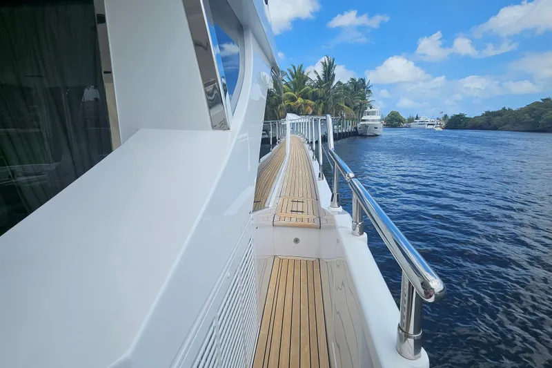  Yacht Photos Pics Side view of 2022 Azimut 66 yacht with wooden deck and scenic waterway.