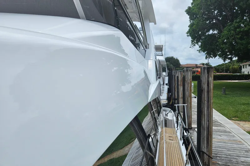  Yacht Photos Pics Side view of a 2022 Azimut 66 yacht docked at a marina.