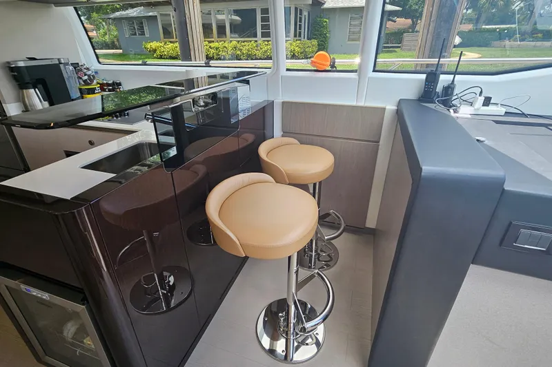  Yacht Photos Pics Luxurious interior of 2022 Azimut 66 yacht with modern bar stools and sleek design.