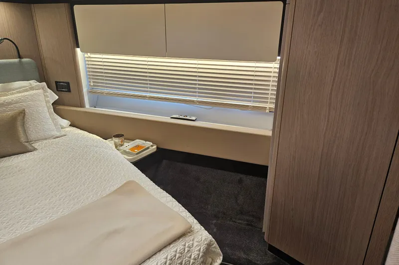  Yacht Photos Pics Luxurious bedroom interior of 2022 Azimut 66 yacht with elegant bedding and modern design.