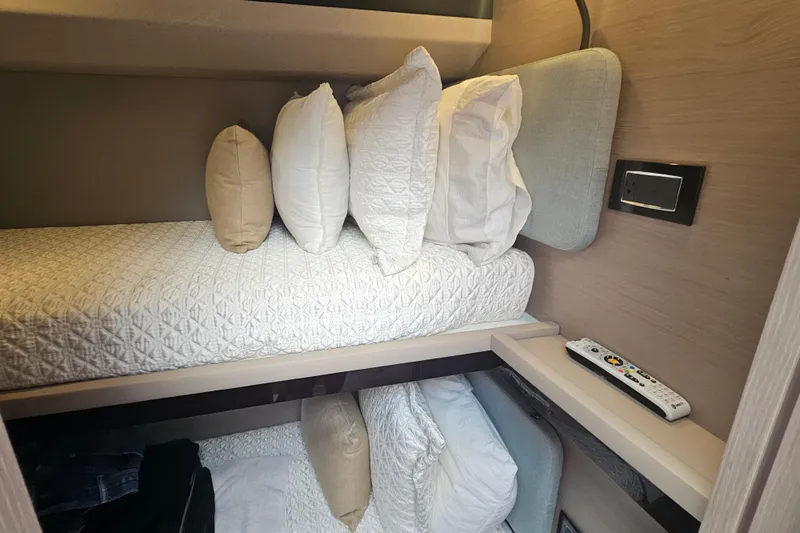  Yacht Photos Pics Cozy cabin interior of 2022 Azimut 66 yacht with bunk beds and remote control.