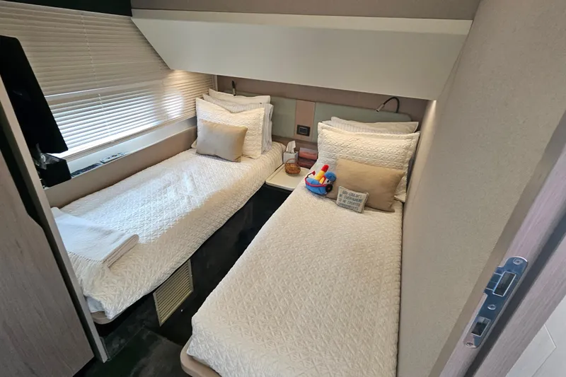  Yacht Photos Pics Luxurious twin cabin in 2022 Azimut 66 yacht with elegant bedding and modern decor.