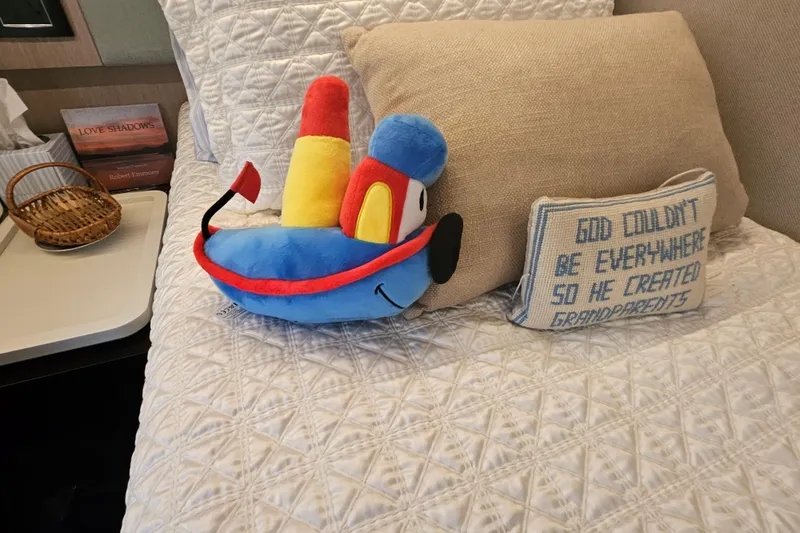  Yacht Photos Pics Plush toy and decorative pillows on a cozy bed in an Azimut 66 yacht cabin.