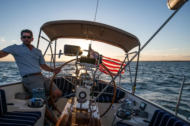 Dream Girl Yacht Photos Pics Man sailing a 2007 Morris Yachts M42 at sunset, American flag waving.