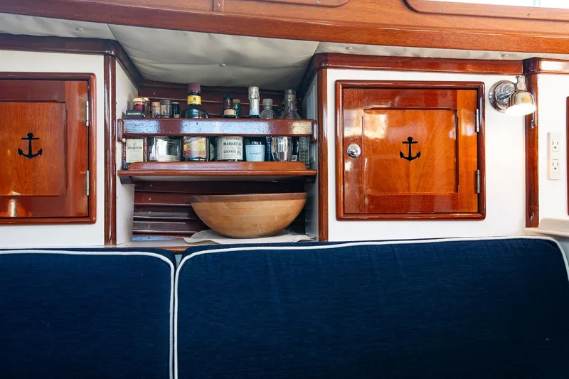 Dream Girl Yacht Photos Pics Interior of 2007 Morris Yachts M42 with wooden cabinets and a stocked bar shelf.