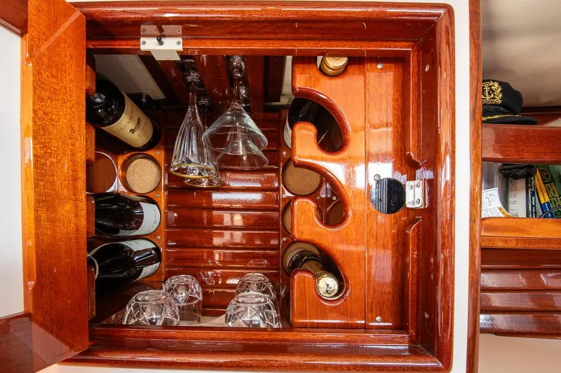 Dream Girl Yacht Photos Pics Luxurious wooden wine cabinet on 2007 Morris Yachts M42, featuring bottles and glasses.