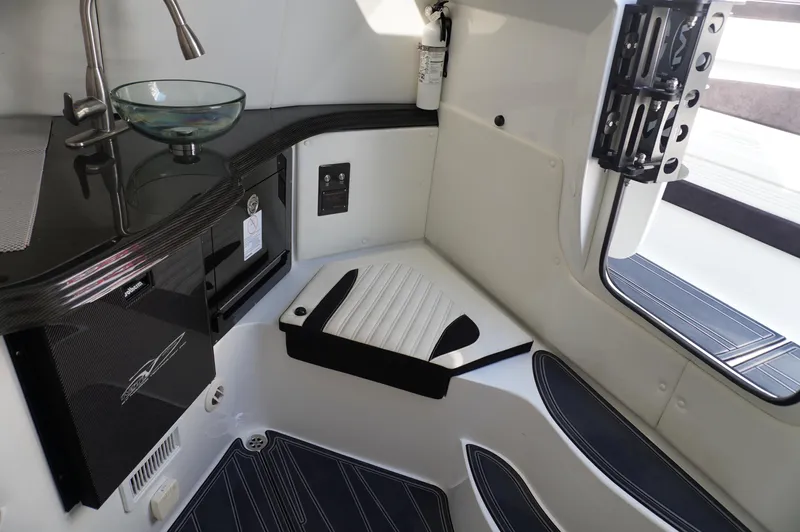  Yacht Photos Pics Modern MTI V42 boat interior with sleek black and white design, featuring a compact sink and seating area.