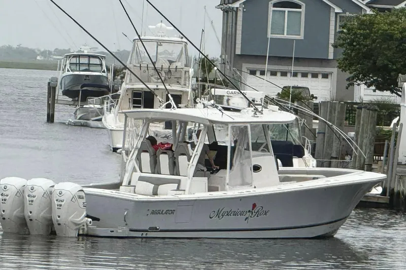  Yacht Photos Pics 2024 Regulator 37 boat docked, featuring multiple outboard engines, near waterfront homes.