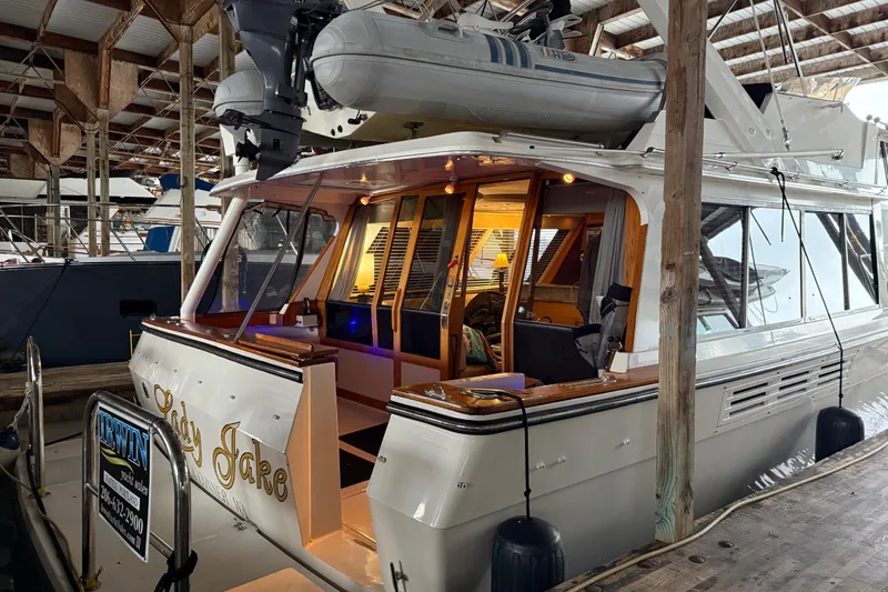 Lady Jake Yacht Photos Pics 1985 Bayliner 4550 Motoryacht docked in a covered marina, with interior lights on.