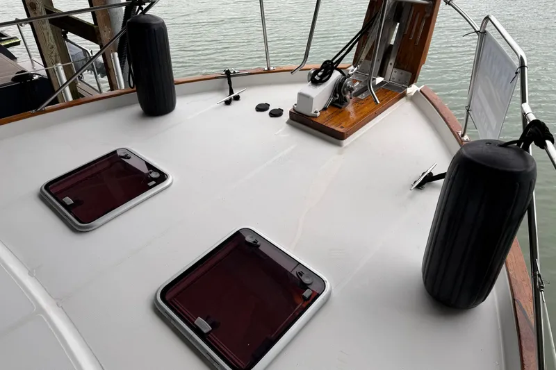 Lady Jake Yacht Photos Pics 1985 Bayliner 4550 Motoryacht deck with hatches and fenders, docked by the water.