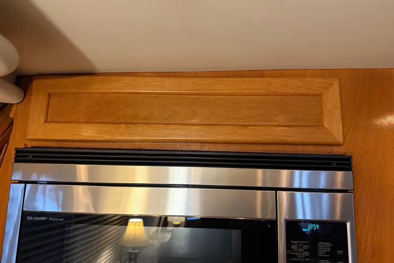 Lady Jake Yacht Photos Pics Microwave in 1985 Bayliner 4550 Motoryacht kitchen with wooden cabinetry.