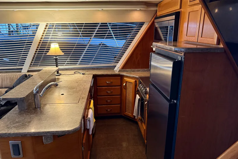 Lady Jake Yacht Photos Pics Interior of 1985 Bayliner 4550 Motoryacht kitchen with modern appliances and wooden cabinetry.