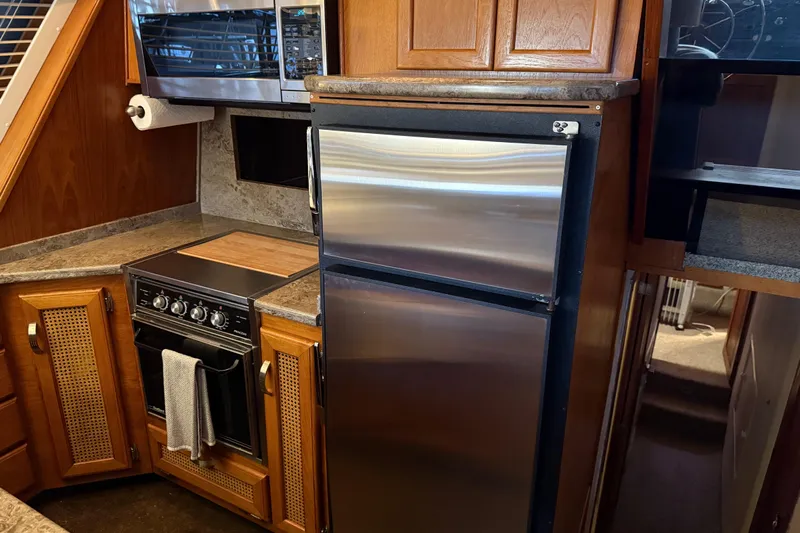 Lady Jake Yacht Photos Pics Galley kitchen in 1985 Bayliner 4550 Motoryacht with stainless steel appliances.