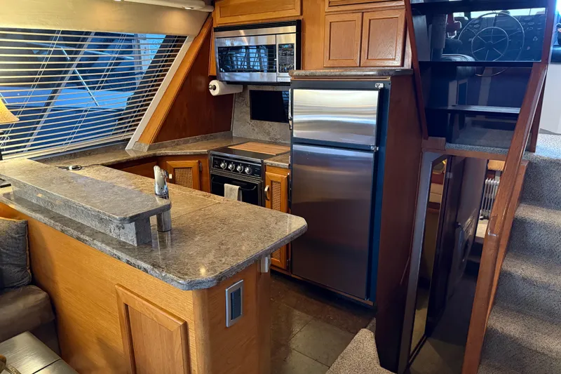Lady Jake Yacht Photos Pics Luxurious 1985 Bayliner 4550 Motoryacht kitchen with modern appliances and elegant wood finishes.