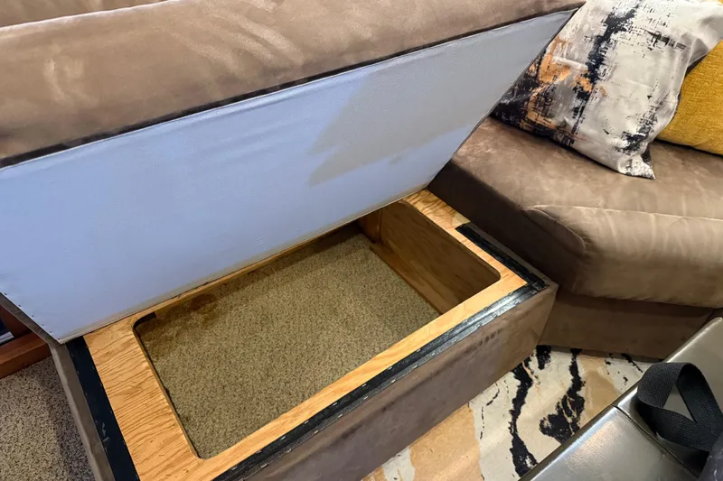 Lady Jake Yacht Photos Pics Open storage compartment in 1985 Bayliner 4550 Motoryacht interior, with cushions and decorative pillows.