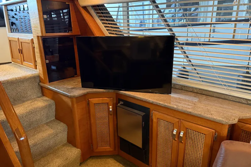 Lady Jake Yacht Photos Pics 1985 Bayliner 4550 Motoryacht interior with TV, wooden cabinetry, and carpeted stairs.