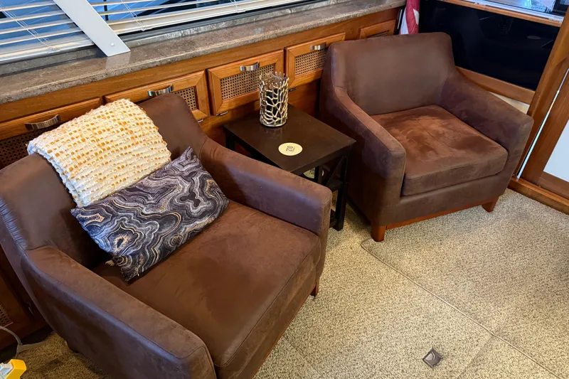 Lady Jake Yacht Photos Pics Cozy seating area on 1985 Bayliner 4550 Motoryacht with brown armchairs and decorative pillows.