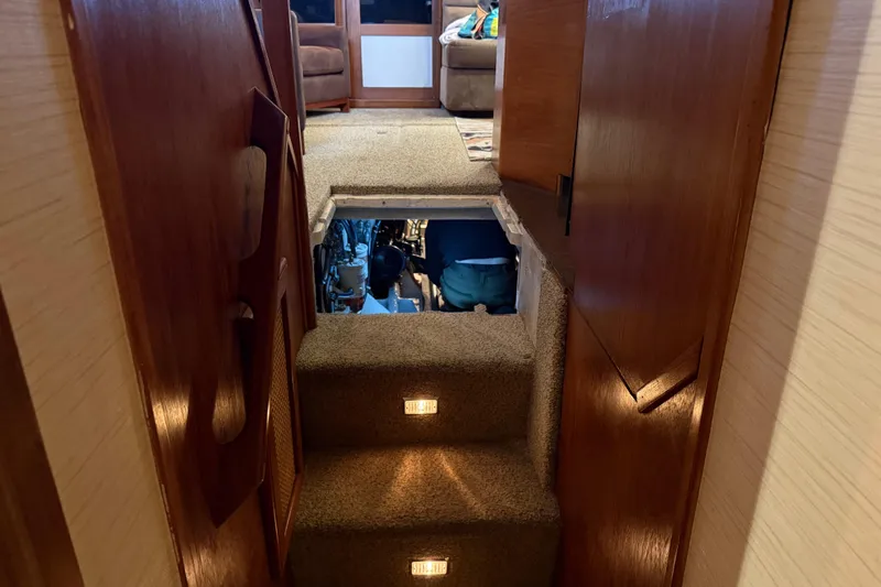 Lady Jake Yacht Photos Pics Interior view of 1985 Bayliner 4550 Motoryacht, showing carpeted stairs and engine access.