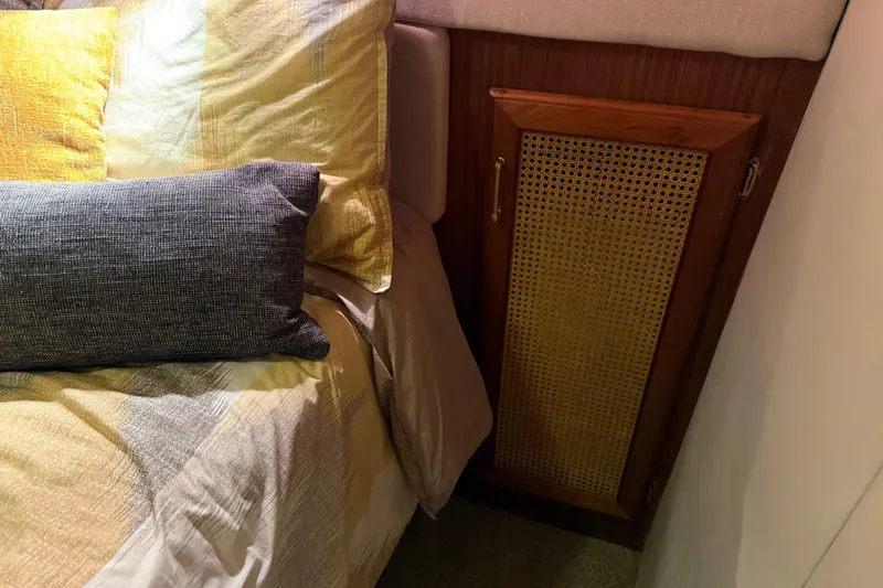 Lady Jake Yacht Photos Pics Cozy bedroom interior of 1985 Bayliner 4550 Motoryacht with wooden cabinet and stylish bedding.