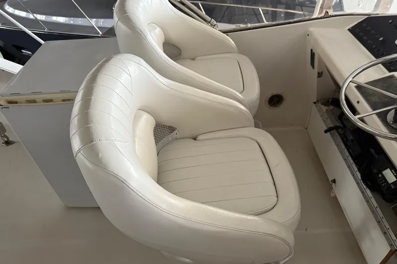 Lady Jake Yacht Photos Pics White captain's chairs on 1985 Bayliner 4550 Motoryacht, featuring a sleek helm design.
