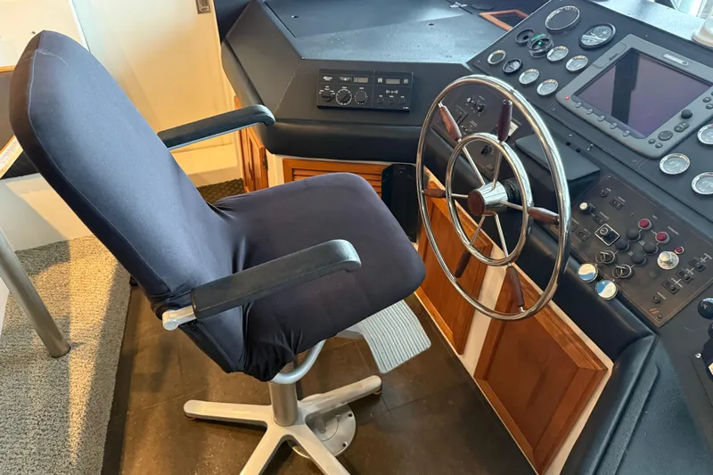 Lady Jake Yacht Photos Pics Captain's chair and helm of 1985 Bayliner 4550 Motoryacht, featuring classic controls and steering wheel.