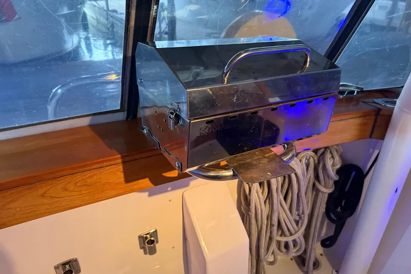 Lady Jake Yacht Photos Pics Stainless steel grill on 1985 Bayliner 4550 Motoryacht, with coiled ropes and wooden trim.