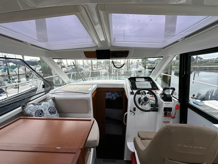 Something Special Yacht Photos Pics Interior view of 2016 Jeanneau Merry Fisher 855 boat, featuring helm and seating area.