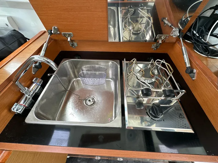 Something Special Yacht Photos Pics Compact kitchen area in a 2016 Jeanneau Merry Fisher 855 with sink and stove.