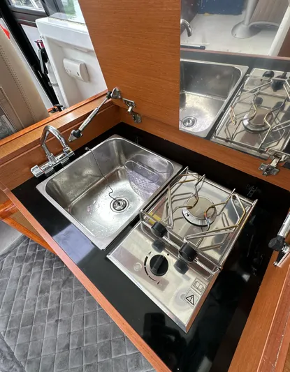 Something Special Yacht Photos Pics Compact kitchen area in a 2016 Jeanneau Merry Fisher 855 boat, featuring a sink and stove.