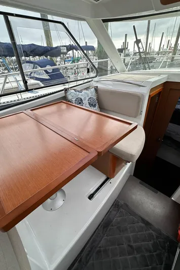 Something Special Yacht Photos Pics Interior of 2016 Jeanneau Merry Fisher 855 with wooden table and marina view.