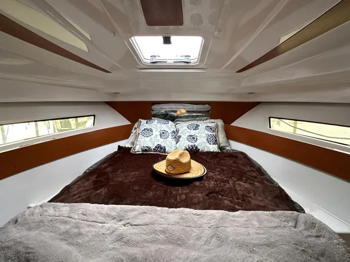 Something Special Yacht Photos Pics Cozy cabin interior of 2016 Jeanneau Merry Fisher 855 with skylight and plush bedding.