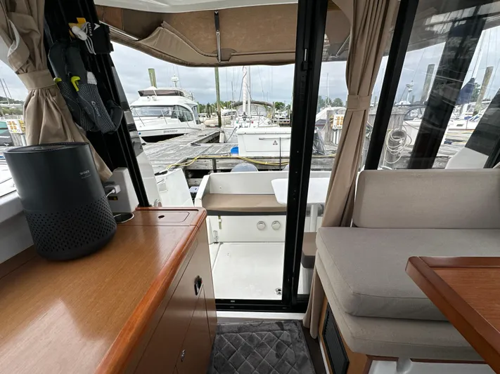 Something Special Yacht Photos Pics Interior view of 2016 Jeanneau Merry Fisher 855 boat, featuring cozy seating and marina backdrop.