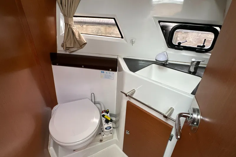Something Special Yacht Photos Pics 2016 Jeanneau Merry Fisher 855 boat bathroom with toilet, sink, and window.